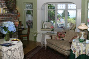Sitting room with fireplace on left and concealed soaker tub beneath the bay window banquette. -- photo by Ingeborg Suzanne